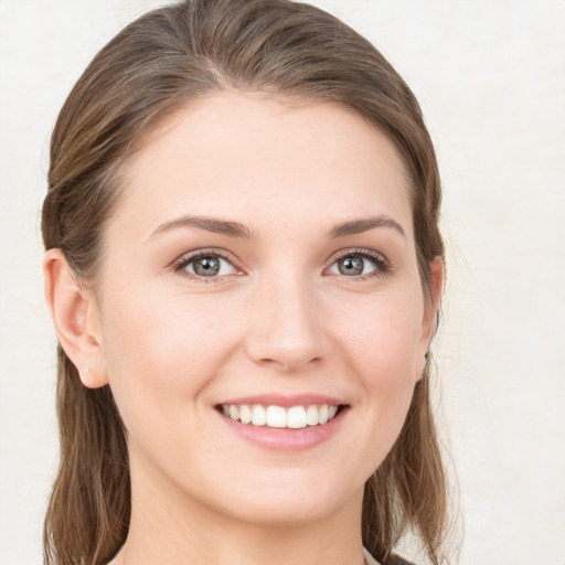 Joyful white young-adult female with medium  brown hair and grey eyes