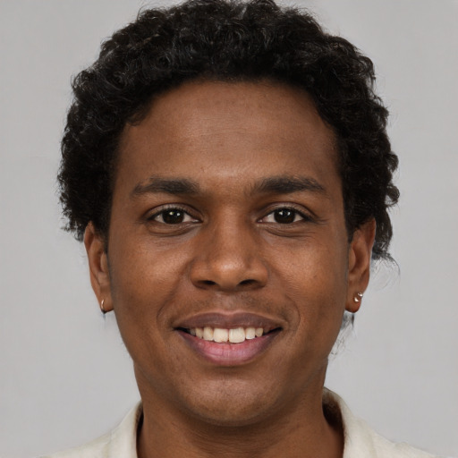 Joyful black young-adult male with short  brown hair and brown eyes