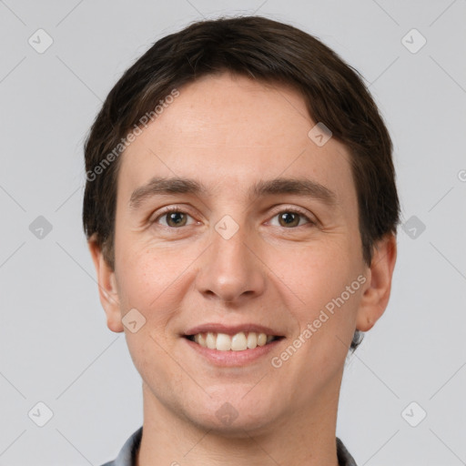 Joyful white young-adult male with short  brown hair and grey eyes