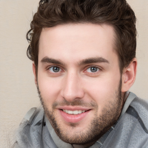 Joyful white young-adult male with short  brown hair and blue eyes