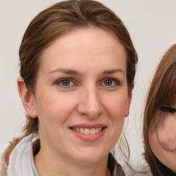 Joyful white adult female with medium  brown hair and brown eyes