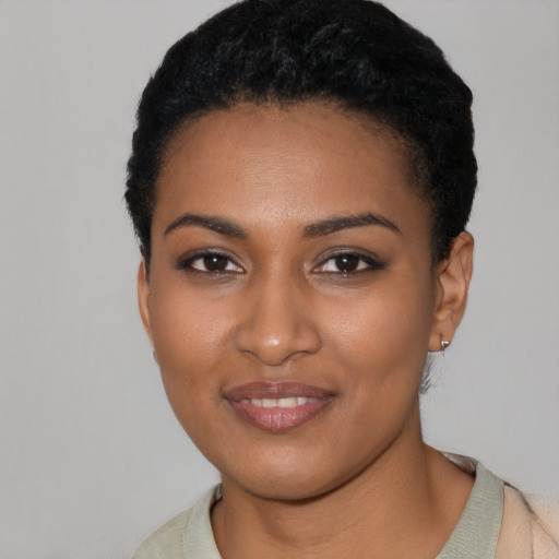Joyful black young-adult female with short  black hair and brown eyes