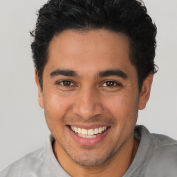 Joyful latino young-adult male with short  brown hair and brown eyes