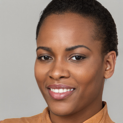 Joyful black young-adult female with short  brown hair and brown eyes