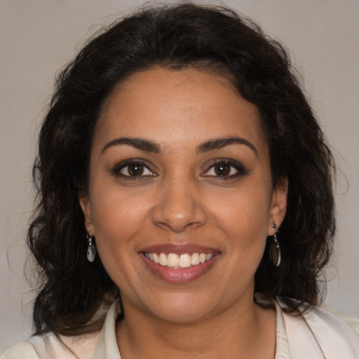 Joyful latino young-adult female with medium  brown hair and brown eyes