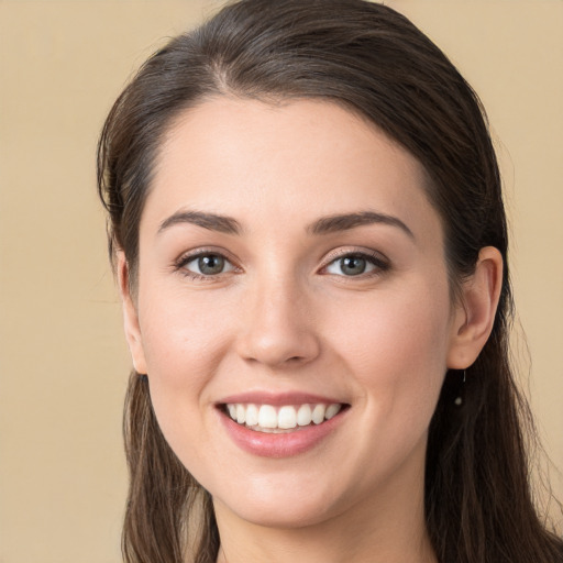 Joyful white young-adult female with long  brown hair and brown eyes