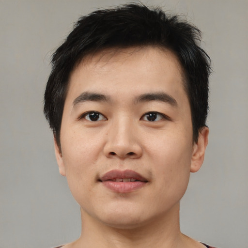 Joyful asian young-adult male with short  black hair and brown eyes