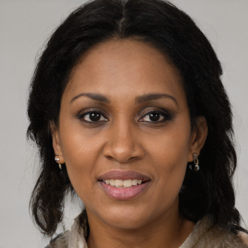 Joyful black young-adult female with long  brown hair and brown eyes