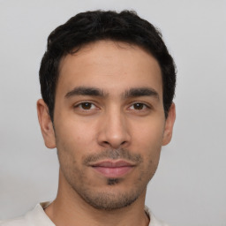 Joyful latino young-adult male with short  brown hair and brown eyes