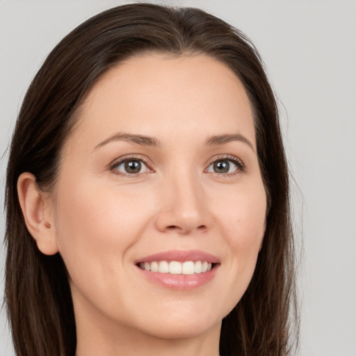 Joyful white young-adult female with long  brown hair and brown eyes