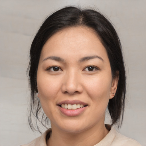 Joyful asian young-adult female with medium  brown hair and brown eyes