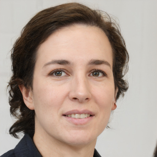 Joyful white adult female with medium  brown hair and grey eyes