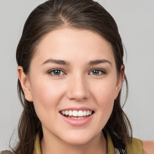 Joyful white young-adult female with long  brown hair and brown eyes