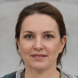 Joyful white adult female with medium  brown hair and grey eyes