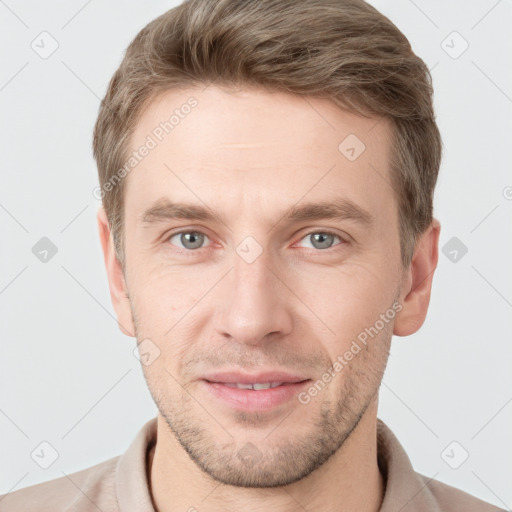 Joyful white young-adult male with short  brown hair and grey eyes