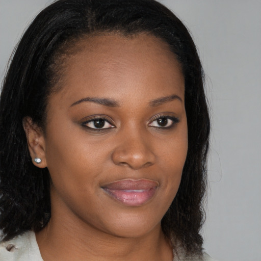 Joyful black young-adult female with long  brown hair and brown eyes