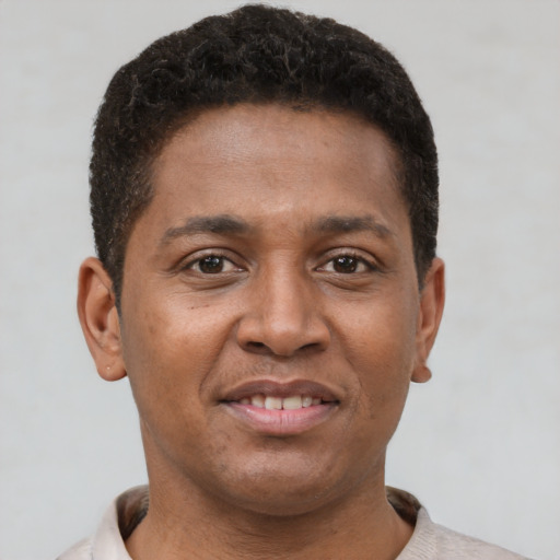 Joyful latino young-adult male with short  brown hair and brown eyes