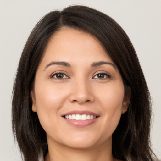 Joyful white young-adult female with long  brown hair and brown eyes