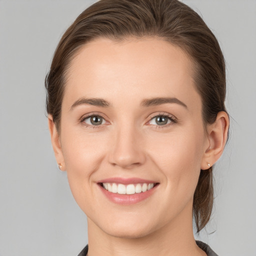 Joyful white young-adult female with medium  brown hair and grey eyes