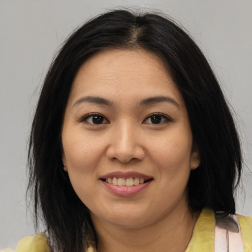 Joyful asian young-adult female with medium  brown hair and brown eyes