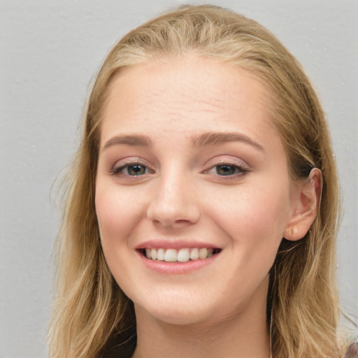 Joyful white young-adult female with long  brown hair and blue eyes