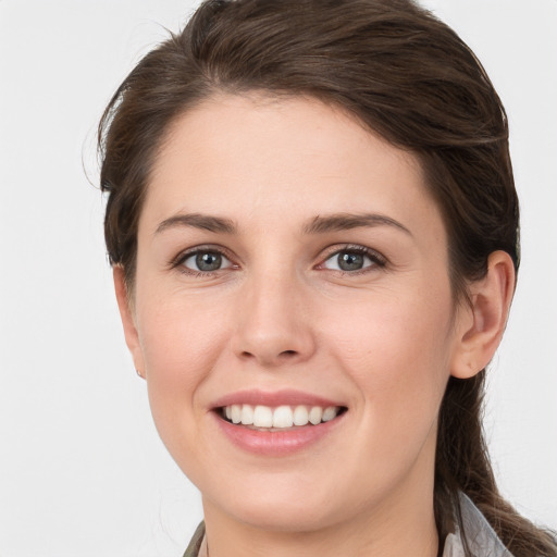 Joyful white young-adult female with medium  brown hair and grey eyes