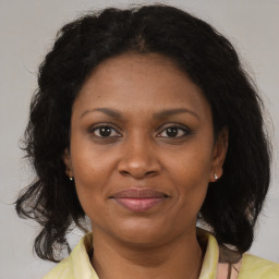 Joyful black adult female with medium  brown hair and brown eyes