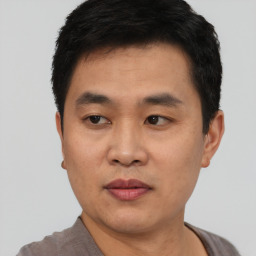 Joyful asian young-adult male with short  black hair and brown eyes