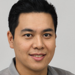 Joyful latino young-adult male with short  brown hair and brown eyes