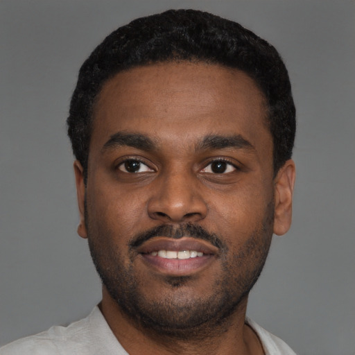 Joyful black young-adult male with short  black hair and brown eyes