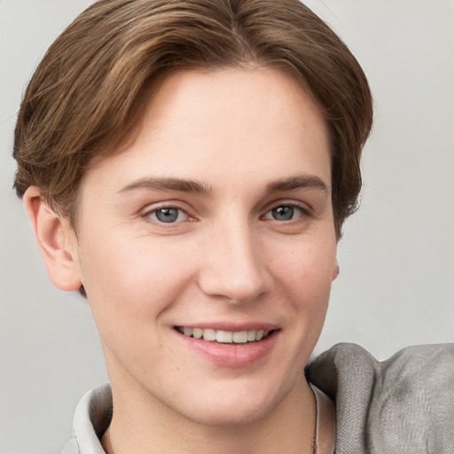 Joyful white young-adult female with short  brown hair and grey eyes