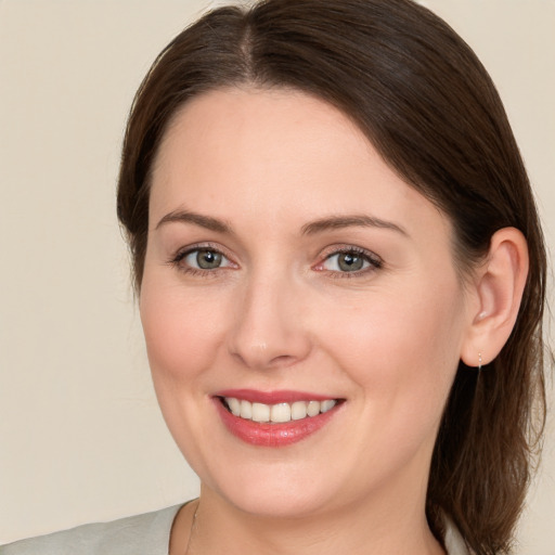 Joyful white young-adult female with medium  brown hair and green eyes