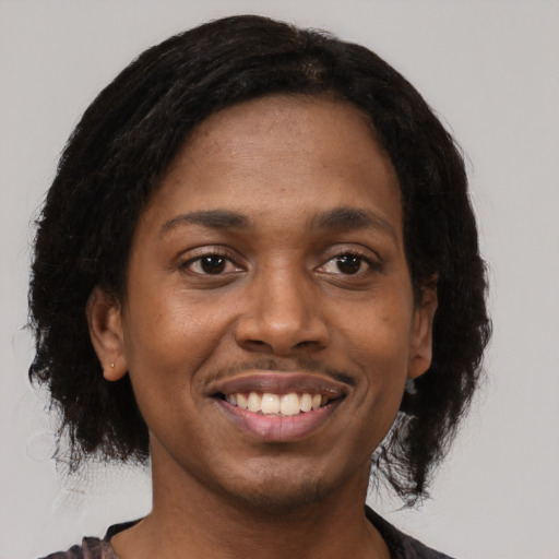 Joyful black young-adult female with short  black hair and brown eyes