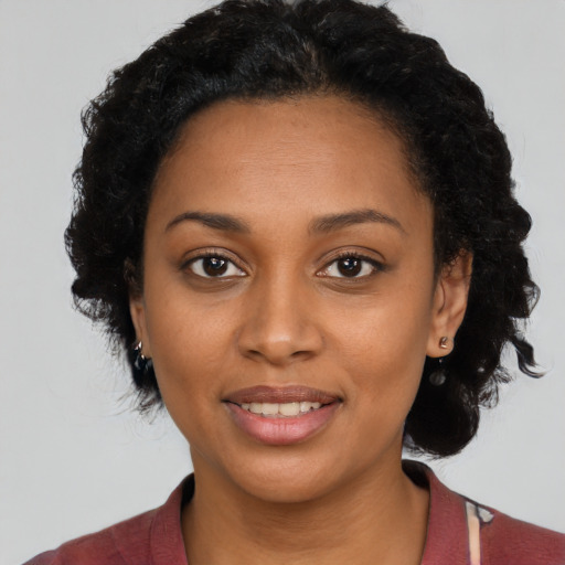 Joyful black young-adult female with medium  black hair and brown eyes