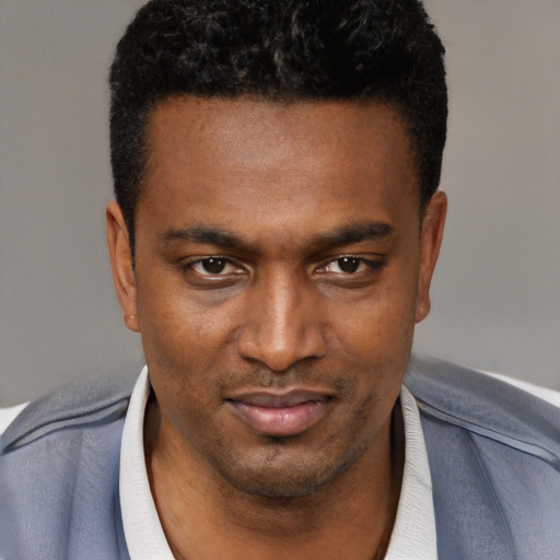 Joyful black young-adult male with short  brown hair and brown eyes