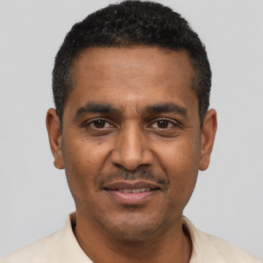 Joyful black adult male with short  black hair and brown eyes