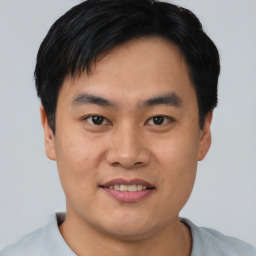 Joyful asian young-adult male with short  black hair and brown eyes