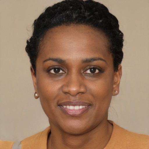 Joyful black young-adult female with short  black hair and brown eyes
