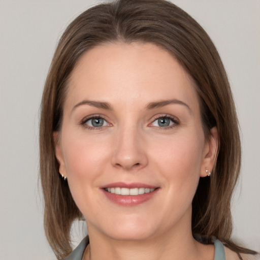 Joyful white young-adult female with medium  brown hair and grey eyes