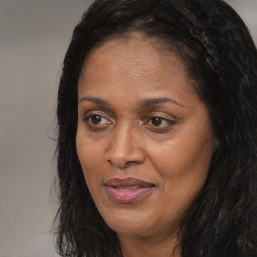 Joyful black adult female with long  brown hair and brown eyes