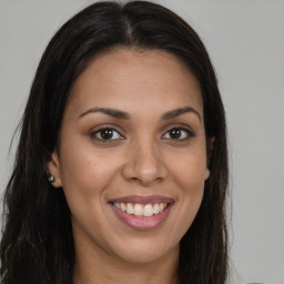 Joyful latino young-adult female with long  brown hair and brown eyes