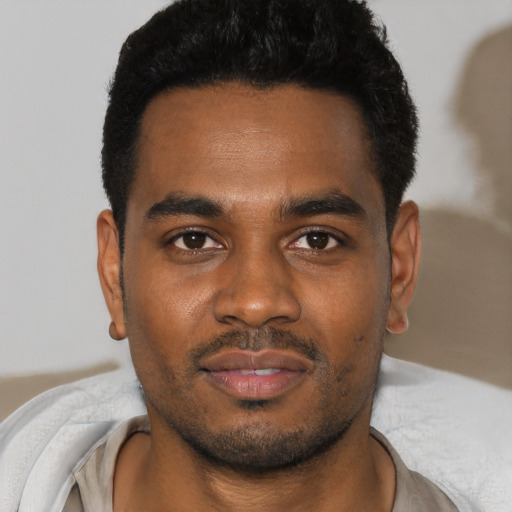 Joyful black young-adult male with short  black hair and brown eyes