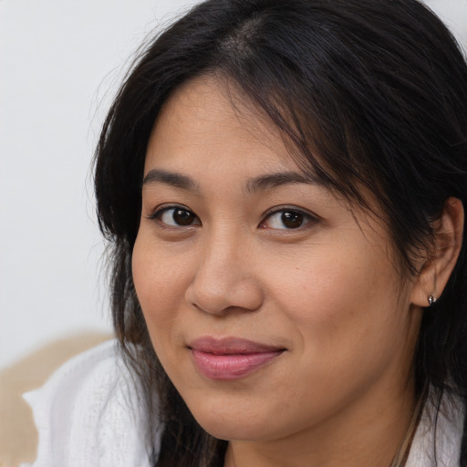 Joyful latino young-adult female with medium  brown hair and brown eyes
