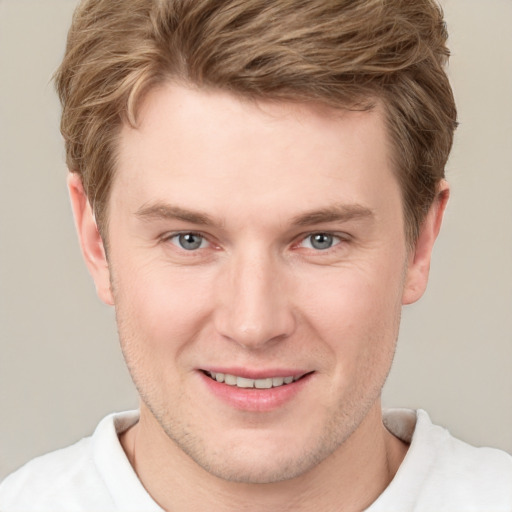 Joyful white young-adult male with short  brown hair and grey eyes