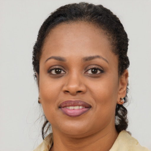 Joyful black young-adult female with long  brown hair and brown eyes