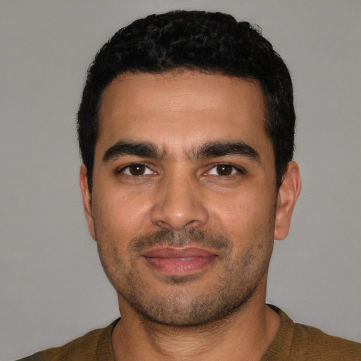 Joyful latino young-adult male with short  black hair and brown eyes