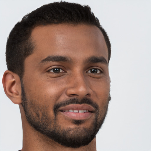 Joyful black young-adult male with short  brown hair and brown eyes