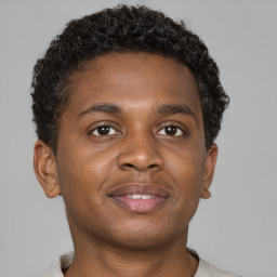 Joyful black young-adult male with short  brown hair and brown eyes