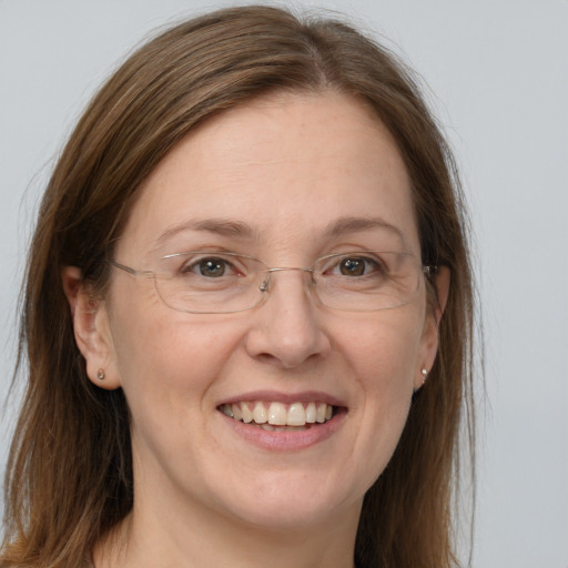 Joyful white adult female with long  brown hair and grey eyes