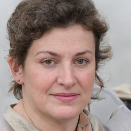 Joyful white adult female with medium  brown hair and blue eyes